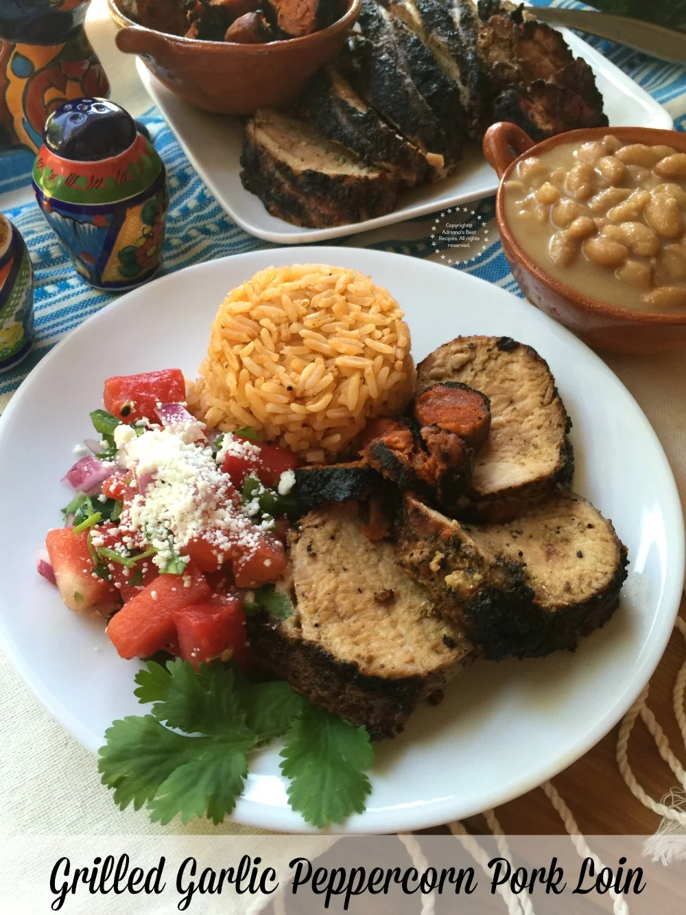 Lomo de cerdo a la pimienta con guarniciones apropiadas para una parrillada estilo mexicano