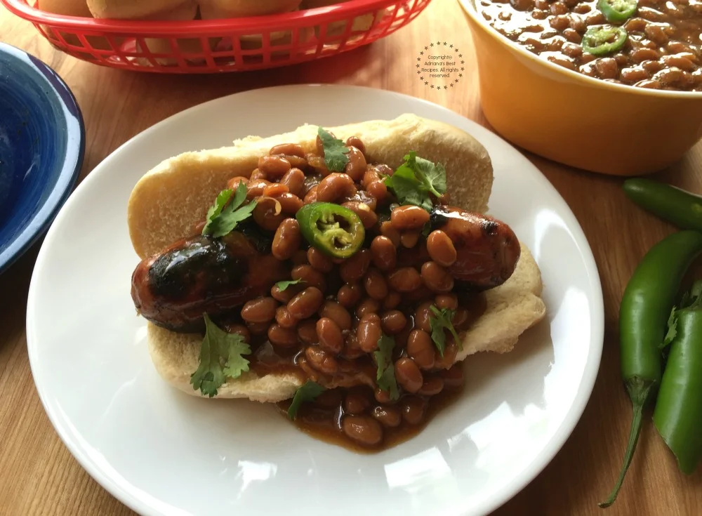 Yummy grilled chicken dogs smothered with sweet and spicy baked beans