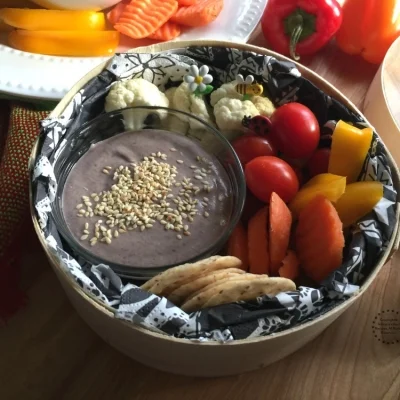 Coloca un poco del humus de frijol en un recipiente y acompaña de verduras y galletas