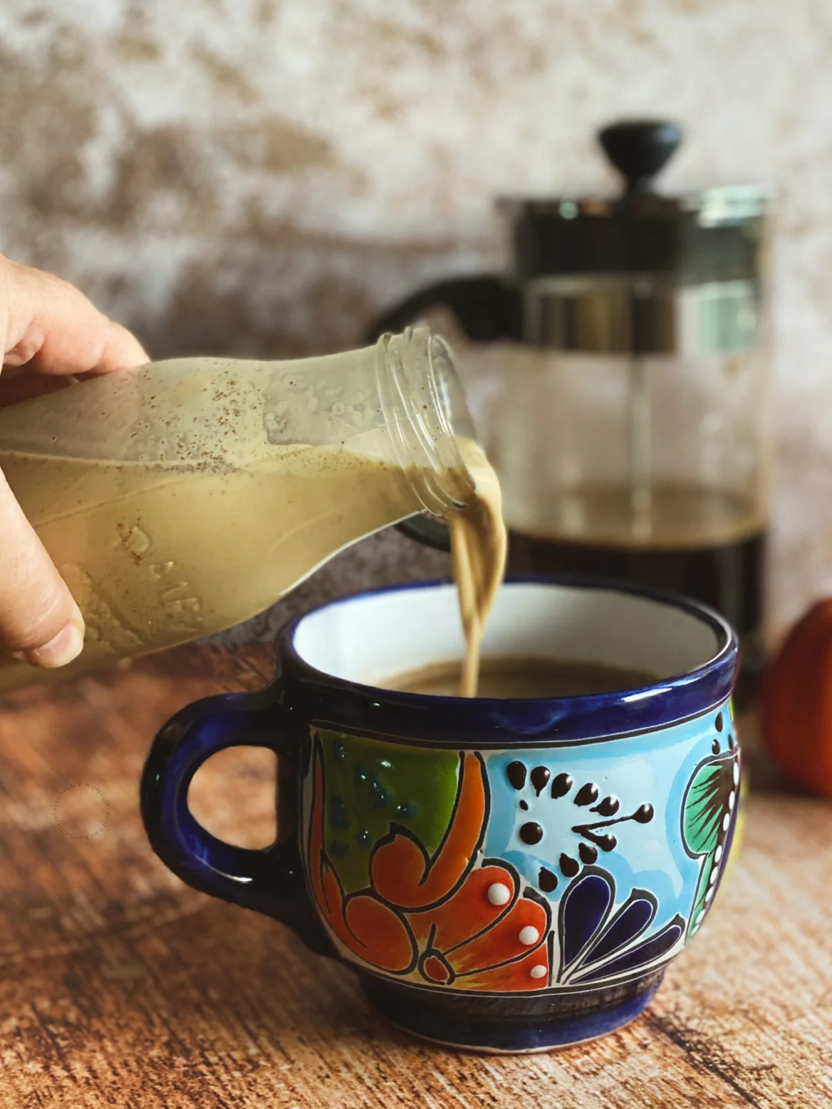 pouring PSL creamer to Mexican coffee