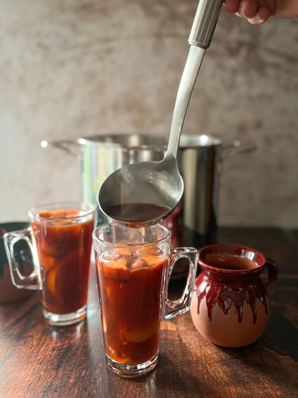 serving the Mexican holiday fruit punch with a ladle